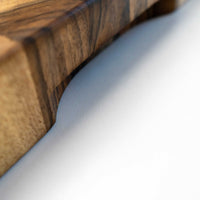 end grain walnut cutting board, handmade in Slovenia. Pictured: side of the board with the carved handle.