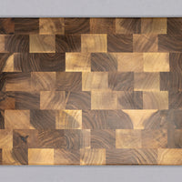 This cutting board is made of walnut wood. In comparison to edge grain boards, end grain cutting boards are gentler to the knife's edge and have a "self-healing" property as the wood fibers close up after they have been cut by the knife, making the board more antibacterial. 50ml of natural mineral oil is included.