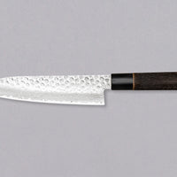 Kawamura Santoku Damascus is a multi-purpose Japanese kitchen knife. The core is made out of stainless AUS-10 steel, wrapped in layers of Damascus steel and the top part of the blade is adorned with hammer prints. The traditional Japanese handle is made out of burnt chestnut wood with a buffalo horn ferrule.