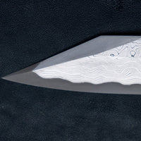 Nigara Kurozome Kiritsuke Yanagiba Aogami #2 Damascus 240mm (9.4") is a traditional single-bevel Japanese knife used for preparing meat and raw fish, especially sashimi and nigiri sushi, and meat. Its length allows the user to slice different types of protein in one single pulling motion, that will – together with the razor-sharp single bevel blade – birth smooth, shiny cuts.