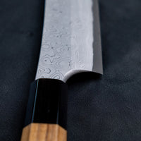 The quality and craftsmanship of this Nigara Kurozome Yanagiba Aogami #2 Damascus 270mm (10.6") is simply superb - from the beautifully polished choil to the unique damascus pattern that surrounds the spine of the blade and extends to its back. The outer layers of the blade have a pearl mosaic-like appearance, which you won't find often even in the most high-end blades.