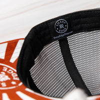 SharpEdge exclusive merch: SharpEdge x Vincent Trinidad Trucker Hat Exclusive SharpEdge design of a brown sumo-fighting bear, armed with our ZDP-189 Bunka Black Japanese knife in collaboration with artist Vincent Trinidad. The bottom of the sturdy visor features the SharpEdge logo within a Japanese rising sun.