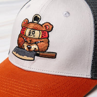 SharpEdge exclusive merch: SharpEdge x Vincent Trinidad Trucker Hat Exclusive SharpEdge design of a brown sumo-fighting bear, armed with our ZDP-189 Bunka Black Japanese knife in collaboration with artist Vincent Trinidad. The bottom of the sturdy visor features the SharpEdge logo within a Japanese rising sun.