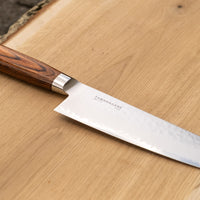 Kengata refers to the shape of the blade similar in usage to a Chef’s knife, but with a more striking look. The blade is finished off with a reversed tanto tip (also known as K-tip). The profile and length are suitable for both long and short cuts, the curve of the belly enables chopping on a kitchen board and the sharp tip excels at tasks where precision is key. The core of the blade has a high-polish finish and is forged out of VG-5 steel .