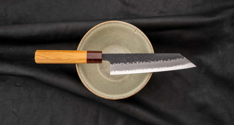 Hokiyama Bunka AS Kurouchi 170mm (6.7") is a multi-purpose knife that will handle all sorts of cutting techniques and is great for preparing fish, meat, and vegetables. Its Aogami Super steel core is protected with san-mai lamination. Fitted with an octagonal Japanese wa handle, made of mahogany and zelkova wood.