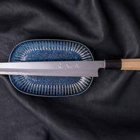 Kawamura Kiritsuke Yanagiba Aogami #1 300mm (11.8") LEFT is one of the rare blades only suitable for left-handed users! It originates from one of the most famous knifemaking centre of Japan, where it was handcrafted by master blacksmiths of the Sakai Kikumori smithy and represents the pinnacle of Japanese knifemaking.