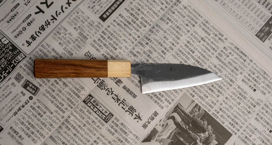 This Ajikiri SUJ-2 blade made by Yoshida Hamono is a Japanese knife for small fish. It's fitted with an octagonal rosewood handle which is topped with a cedar ferrule. The blade is forged from SUJ-2 steel with a hardness is 63-64 HRC, which holds its edge for a long time and is very easy to resharpen.