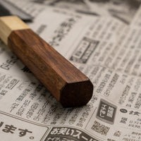 This Ajikiri SUJ-2 blade made by Yoshida Hamono is a Japanese knife for small fish. It's fitted with an octagonal rosewood handle which is topped with a cedar ferrule. The blade is forged from SUJ-2 steel with a hardness is 63-64 HRC, which holds its edge for a long time and is very easy to resharpen.