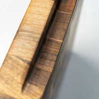 end grain walnut cutting board, handmade in Slovenia. Pictured: side of the board with the carved handle.