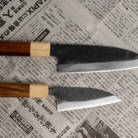 Meet your new favorite power couple - The Carbons. The set consists of Yoshida Ajikiri 100mm (3.9") and Yoshida Santoku Funayuki 155mm (6.1"). Small yet fierce, these two hand-forged knives are made from high-carbon SUJ-2 steel (63-64 HRC), known for its fine sharpness, long edge retention, and ease of sharpening. 