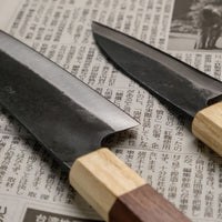 Meet your new favorite power couple - The Carbons. The set consists of Yoshida Ajikiri 100mm (3.9") and Yoshida Santoku Funayuki 155mm (6.1"). Small yet fierce, these two hand-forged knives are made from high-carbon SUJ-2 steel (63-64 HRC), known for its fine sharpness, long edge retention, and ease of sharpening. 