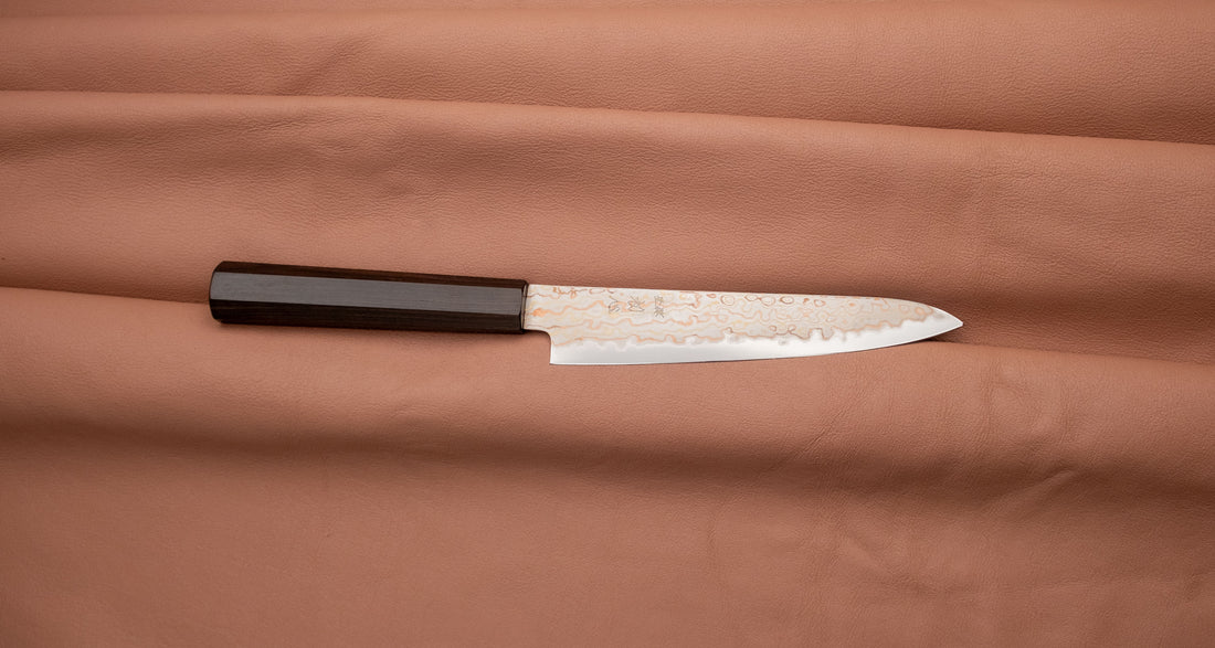 Hayabusa Petty Aogami #2 Rainbow Damascus 150mm is a versatile Japanese kitchen knife ideal for preparing meat, fish, and vegetables. Its blade, made of Aogami #2 steel, is thin and precise. It excels in sharpness, edge retention, and ease of maintenance, but above all looks - with the unique rainbow damascus pattern!