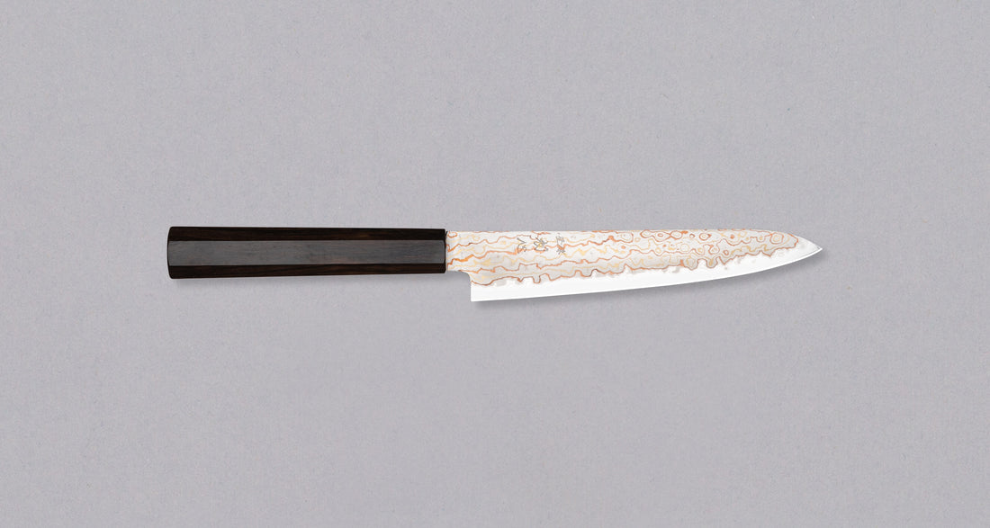 Hayabusa Petty Aogami #2 Rainbow Damascus 150mm is a versatile Japanese kitchen knife ideal for preparing meat, fish, and vegetables. Its blade, made of Aogami #2 steel, is thin and precise. It excels in sharpness, edge retention, and ease of maintenance, but above all looks - with the unique rainbow damascus pattern!