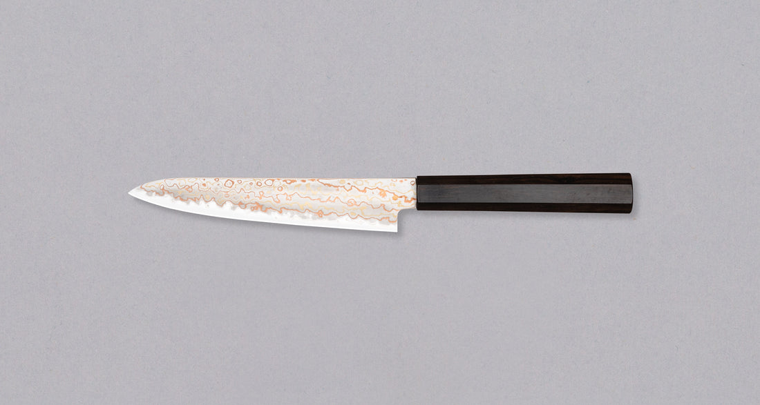 Hayabusa Petty Aogami #2 Rainbow Damascus 150mm is a versatile Japanese kitchen knife ideal for preparing meat, fish, and vegetables. Its blade, made of Aogami #2 steel, is thin and precise. It excels in sharpness, edge retention, and ease of maintenance, but above all looks - with the unique rainbow damascus pattern!