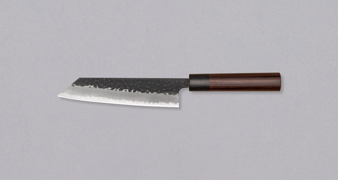 Hokiyama Bunka AS Kurouchi 170mm (6.7") is a multi-purpose knife that will handle all sorts of cutting techniques and is great for preparing fish, meat, and vegetables. Its Aogami Super steel core is protected with san-mai lamination. Fitted with an oval Japanese wa handle, made of rosewood.