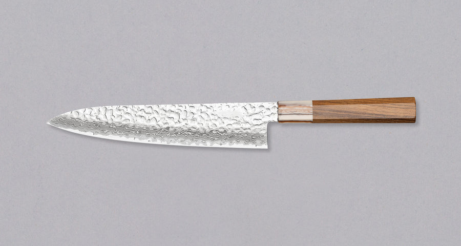 The Kotetsu Gyuto VG-10 Damascus 210mm (8.2") is a large multi-purpose Janapese knife with visible hammer prints, a damascus pattern and a classic Japanese (wa-style) teak handle. It will impress anyone who appreciates aesthetically designed kitchen utensils.