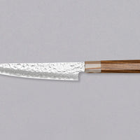 The Kotetsu VG-10 Damascus Petty 150 mm is a small Janapese knife with visible hammer prints, a damascus pattern and a classic Japanese (wa-style) teak handle. VG-10 stainless steel ensures rust resistance, durability, and wear resistance. Because it is low-maintenance, it is suitable as a first Japanese kitchen knife.