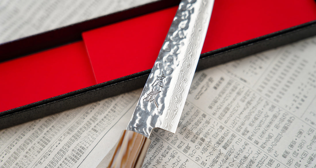 The Kotetsu VG-10 Damascus Petty 150 mm is a small Janapese knife with visible hammer prints, a damascus pattern and a classic Japanese (wa-style) teak handle. VG-10 stainless steel ensures rust resistance, durability, and wear resistance. Because it is low-maintenance, it is suitable as a first Japanese kitchen knife.
