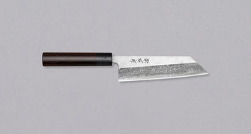 Muneishi Bunka Aogami #2 Damascus 165mm is a multi-purpose Japanese kitchen knife, suitable for preparing meat, fish and vegetables, with a special "K-tip" for precise cuts. The minimalistic polished blade finish shifts into a misty damascus pattern, giving the knife an elegant, dreamy look. Fitted with rosewood handle.