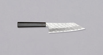 Nigara Bunka VG-10 Damascus Tsuchime is a multi-purpose Japanese kitchen knife, suitable for preparing meat, fish, and vegetables. Its VG-10 stainless steel core ensures a fine sharpness with little to no maintenance. As such, the knife is also suitable as a first Japanese knife or gift. Fitted with ebony handle.