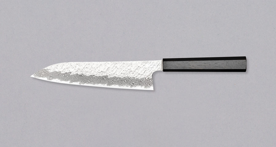 Nigara Gyuto VG-10 Damascus Tsuchime 210mm (8.2") is a multi-purpose Japanese kitchen knife, suitable for preparing meat, fish, and vegetables. VG-10 stainless steel ensures a fine sharpness with little to no maintenance. As such, the knife is also suitable as a first Japanese knife or gift. Fitted with an ebony handle.
