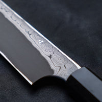The quality and craftsmanship of this Nigara Kurozome Yanagiba Aogami #2 Damascus 270mm (10.6") is simply superb - from the beautifully polished choil to the unique damascus pattern that surrounds the spine of the blade and extends to its back. The outer layers of the blade have a pearl mosaic-like appearance, which you won't find often even in the most high-end blades.