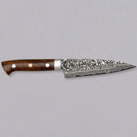 Saji Petty R2 Ironwood 130mm is not just a looker. The core is made of powder R2/SG2 steel, tempered to around 63 HRC, and clad into layers of rust-resistant stainless steel which creates a unique damascus pattern. The knife is stored in a traditional Japanese wooden box with burned Saji trademark kanji on top.