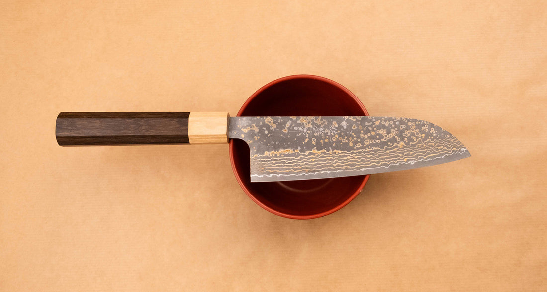 Saji&nbsp;Santoku VG-10 Gold RWO 165mm&nbsp;is a versatile Japanese kitchen knife suitable for preparing meat, fish and vegetables. However, it would be an injustice to call it just a kitchen knife, as it is a remarkable example of blacksmith's craftsmanship - from its unique design to its very&nbsp;specific features.