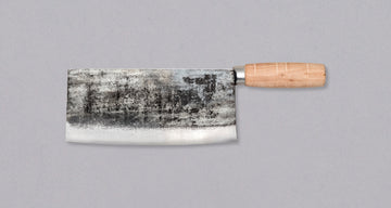 The Sentan Chinese Cleaver Shirogami #2 200mm is quite light for a Chinese cleaver. As for steel, the blacksmith opted for Shirogami #2 (White) steel, with a hardness of 60 HRC.  Suitable for vegetables, as well as slicing raw fish and meat, but not bones. It boasts a rustic kurouchi finish and a round wooden handle.
