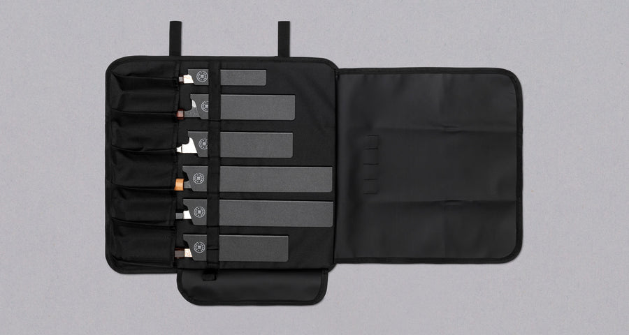 Our SharpEdge Black Chef's Knife Roll is best suited for chefs on-the-go and home cooks who need a sturdy knife roll that can hold very long knives (up to 440mm (17.3")). It has 6 pockets for knives and utensils, and additional velcro fasteners to keep them in place. A minimalistic, durable black knife bag. Get yours.