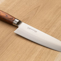 Tamahagane San Santoku in 160mm (6.3") blade length is a universal knife that will excel at a variety of cutting and chopping on a cutting board. A polished blade finish, featured with the core VG-5 steel hardened to 61 HRC.