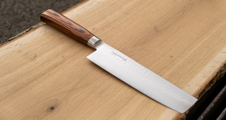 Tamahagane Nakiri is a traditional Japanese knife with a square, thin blade and a deep, flat belly. Perfect knife for cutting vegetables. A matte blade finish, featured with the core VG-5 steel hardened to 61 HRC.