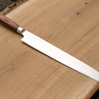 Tamahagane Tsubame Slicer knife is primarily intended for long pulls and precise cuts of meat and fish. The 240mm (9.5") version is designed for medium-sized fish and pieces of meat. A matte blade finish, featured with the core VG-5 steel hardened to 61 HRC.