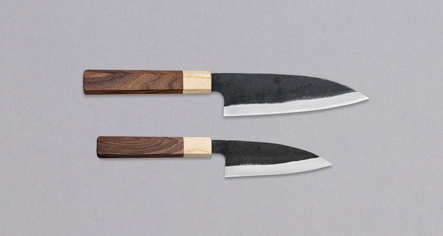 Meet your new favorite power couple - The Carbons. The set consists of Yoshida Ajikiri 100mm (3.9") and Yoshida Santoku Funayuki 155mm (6.1"). Small yet fierce, these two hand-forged knives are made from high-carbon SUJ-2 steel (63-64 HRC), known for its fine sharpness, long edge retention, and ease of sharpening. 