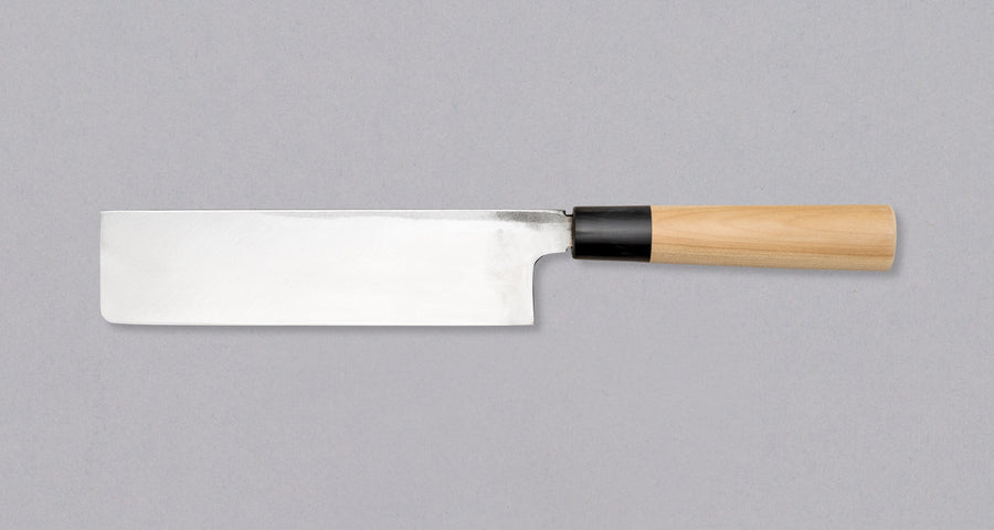 Kakugata Usuba is forged from Shirogami #1, one of the purest and most traditional steels used in Japanese knife manufacturing. Fitted with a Japanese handle made of magnolia wood topped with a buffalo horn ferrule, this minimalistic knife showcases the qualities of traditional Japanese blades we like most.