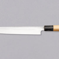 Pictured: Japanese knife Tojiro Yanagiba from the back. Tojiro Yanagiba 240mm (9.4") is a handy low-maintenance single-bevel knife suitable for preparing meat and fish. With a core of Shirogami #1 steel and ni-mai lamination, it is easy to resharpen and keep sharp long-term. It features a D-shaped magnolia handle with a water buffalo horn ferrule, and a migaki blade finish.