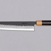 Tsunehisa Kiritsuke AS Kuro-uchi 240mm (9.4") is a multi-purpose knife with a black Kuro-uchi protective patina and tsuchime hammer indentations. Its length makes it great for cutting larger pieces of meat and fish. The Kuro-uchi (black) patina on the upper part of the knife gives it a unique and rustic appearance.