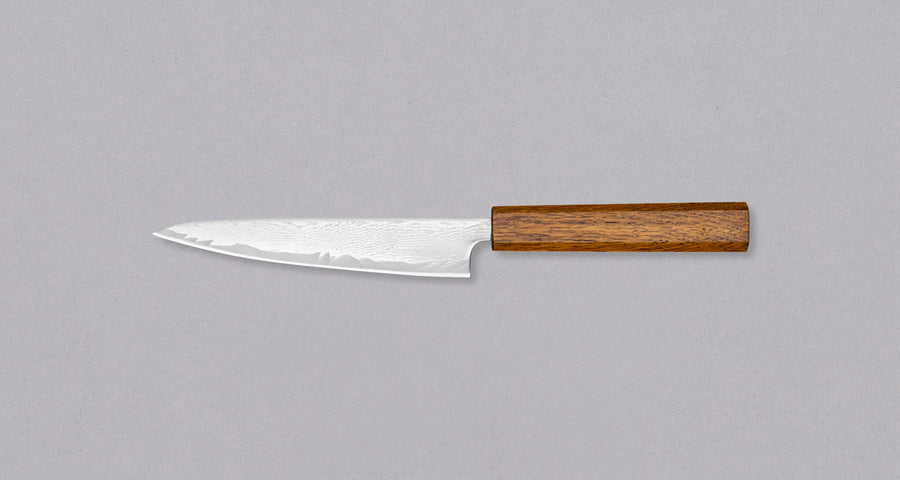 Tsunehisa Petty AUS-10 Nami 150mm (5.9") is a small multi-purpose Japanese kitchen knife, suited for all smaller cutting tasks either in hand or on the cutting board. Made from AUS-10 stainless steel (62 HRC) that has great edge retention. The migaki damascus blade is fitted with an oak octagonal handle.