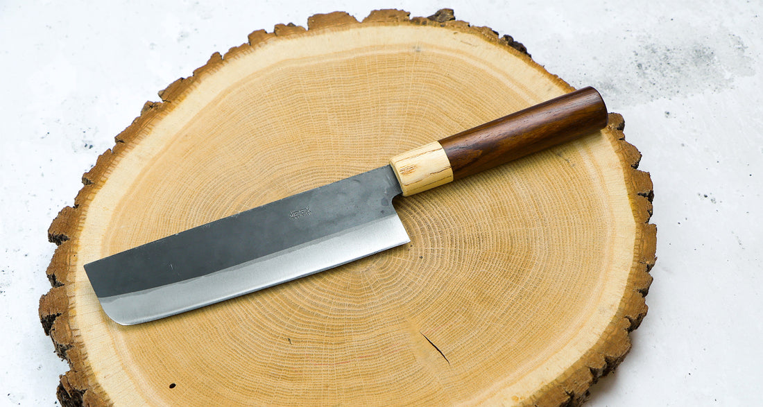 This Nakiri Kyusyu SUJ-2 blade is fitted with an oval rosewood handle, topped with a cedar ferrule. A traditional Japanese knife for cutting vegetables. The blade is forged from SUJ-2 steel with a hardness is 63-64 HRC, which holds its edge for a long time and is very easy to resharpen.ž