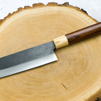 This Nakiri Kyusyu SUJ-2 blade is fitted with an oval rosewood handle, topped with a cedar ferrule. A traditional Japanese knife for cutting vegetables. The blade is forged from SUJ-2 steel with a hardness is 63-64 HRC, which holds its edge for a long time and is very easy to resharpen.ž