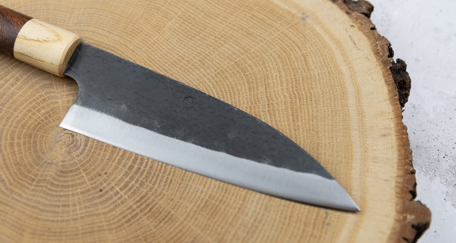 This Santoku Funayuki SUJ-2 blade is fitted with an oval rosewood handle with a cedar ferrule. Great for cutting smaller pieces of meat and filleting fish.  The blade is forged from SUJ-2 steel, which offers incredible capacities, hardness is 63-64 HRC, and at the same time, the knife is very easy to resharpen. 
