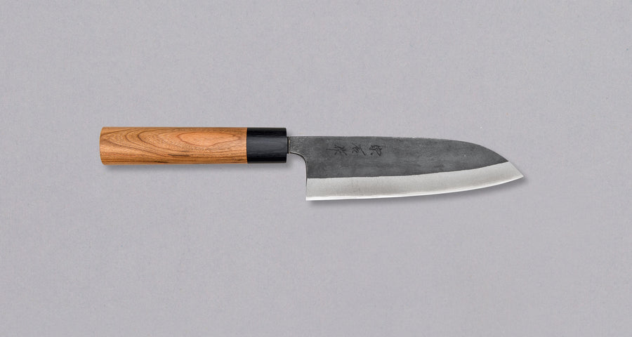 Muneishi Santoku Aogami #2 Kuro-uchi 210mm is a multi-purpose Japanese kitchen knife, suitable for preparing meat, fish, and vegetables. High-carbon Aogami #2 steel is easy to sharpen to a very fine sharpness. A  beautiful cherry wood oval handle has a pakka ferrule – providing a nice contrast to the dark blade.