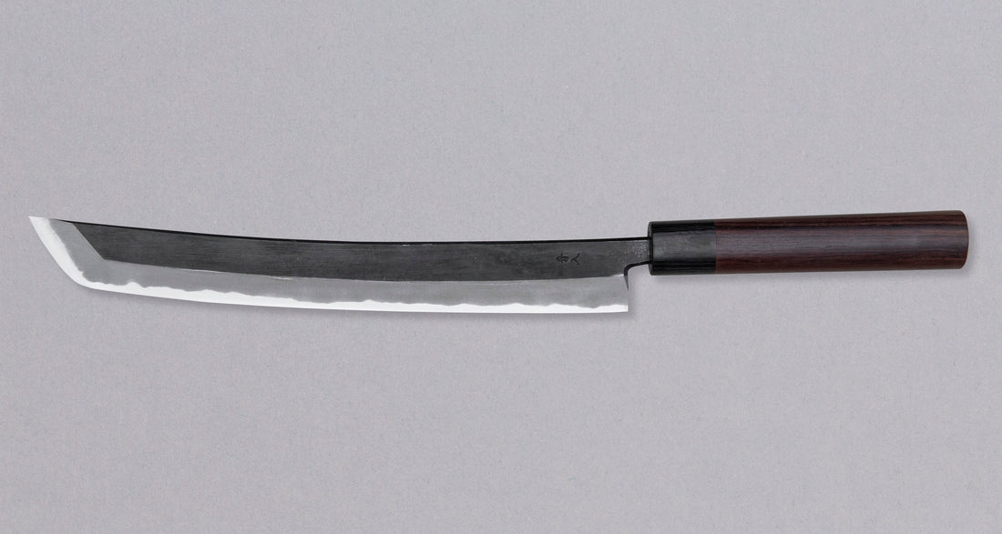 The Tsunehisa Sakimaru Sujihiki Aogami #2 300mm is a traditional Japanese knife used for preparing meat and fish, especially for sashimi and nigiri sushi. The name sakimaru refers to the tanto tip, which is one of the main features of a katana.