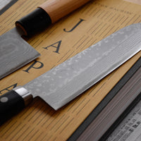 Etsu Village Damascus Santoku Black 170mm (6.7")_4  Damascus Santoku Black features a Western-style (Yo) handle from black micarta. This knife will be a great addition to your kitchen, suitable for cutting veggies, meat and fish. Blacksmith Masutani is known as an incredibly good knife sharpener, and his knives are no different, featuring a very thin spine (around 1.8mm).